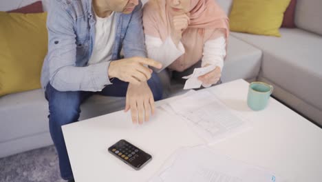 Muslim-couple-checking-payment-bills-at-home.